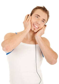 Smiling handsome young man in casual style with headphones is listening music, isolated on white background