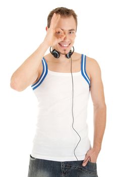 Smiling handsome young man in casual style with headphones shows sign ok, isolated on white background