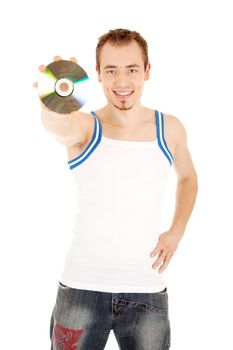 Handsome smiling young man in T-shirt is showing a compact disk. Isolated on white background.
