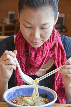 Women are eating the delicious noodles.