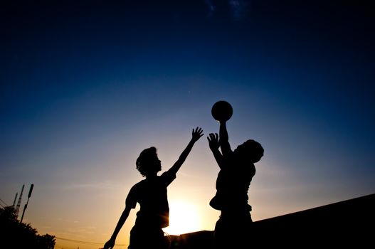 silhouette of man playing basketball