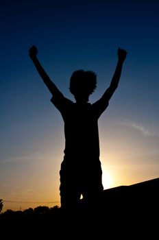 silhouette of man jumping for victory