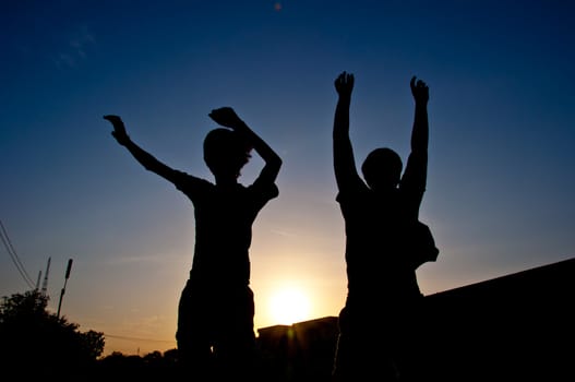 silhouette of man jumping for victory