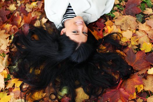 woman lay on yellow autumn leaves