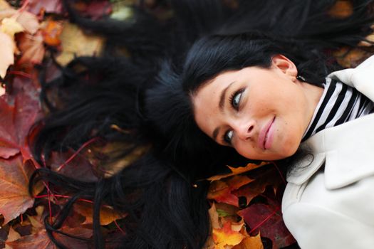 woman lay on yellow autumn leaves