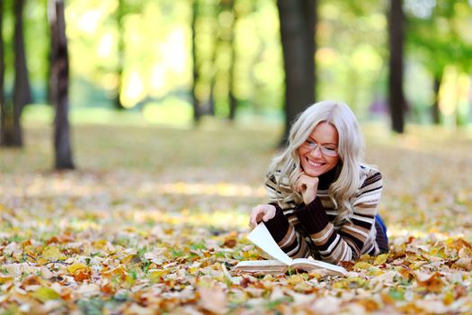 woman read the book in autumn park