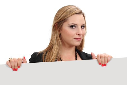 Photo of a beautiful blond female holding a blank sign - ready for your advertisement or message. Clipping path for sign and shadows included.