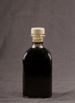 Elegant bottle of balsamic vinegar over brown background