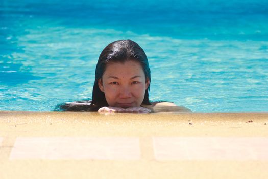 Woman swimming happily in the pool