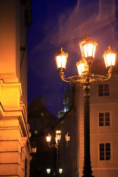 Narrow night street with vintage luminous lanterns. Prague,Czech Republic