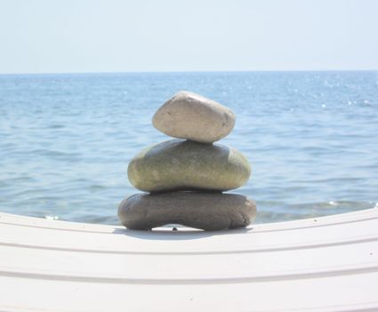 The stack of pebble stones in zen concept  on chaise longues 