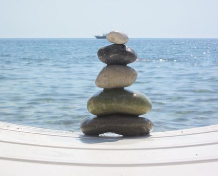 The stack of pebble stones in zen concept  on chaise longues 