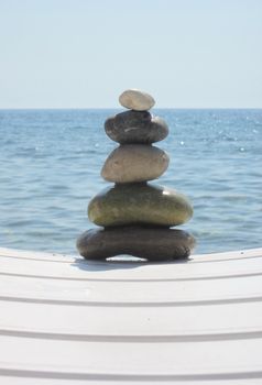 The stack of pebble stones in zen concept  on chaise longues 