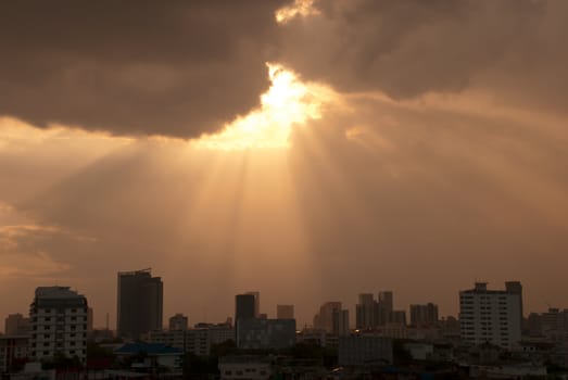 Rays of sunlight bursting through clouds above Bangkok City