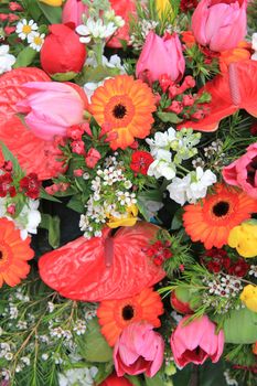 Flower arrangement with different flowers in orange, yellow, pink and red