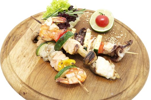skewers of seafood on a wooden platter in a restaurant