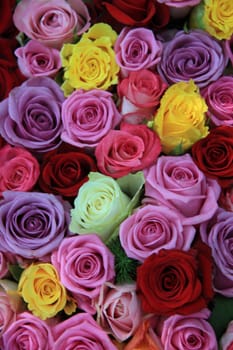 Big roses in many different bright colors in a floral arrangement