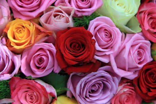 Big roses in many different bright colors in a floral arrangement