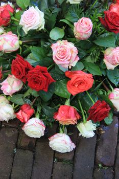 Wet sympathy flower bouquet on the pavement, mixed roses