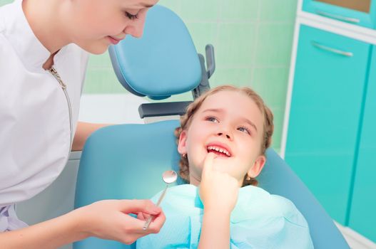 child shows the tooth dentist, regular visits to the doctor