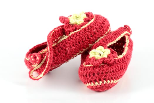 Baby shoes made ​​with wool burgundy and yellow on white background