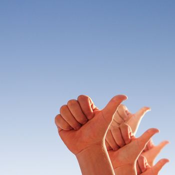 men's hands make thumbs up on blue sky