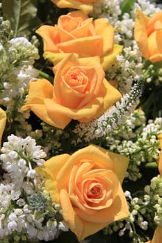 Wedding flower arrangement with yellow roses and white common lilac