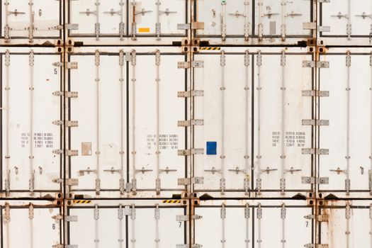 Background texture pattern of stacked white metal shipping containers at freight depot to be shipped to global destinations