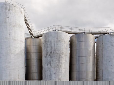 Group of large steel storage tanks at a refinery terminal used for storage and distribution of petrochemical products