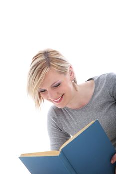Young woman smiling in pleasure as she enjoys reading her book isolated on white 