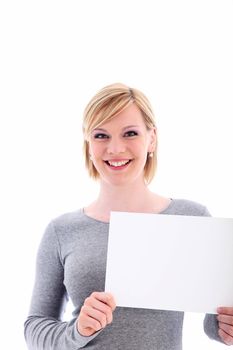 Friendly young blonde woman with a lovely wide smile holding up a blank sign for your advertisement or promotion 