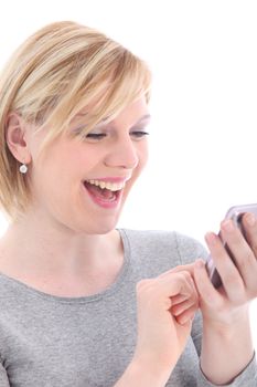 Laughing young woman reading a text message on her mobile phone isolated on white 