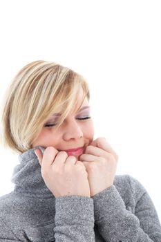 Cold woman pulling the collar of her warm jacket high around her cheeks suffering with freezing winter temperatures 