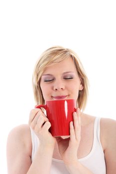 Woman savouring a mug of hot coffee with her eyes closed in bliss as she smells the rich aroma 