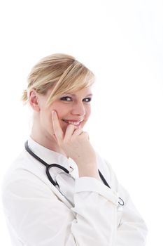 Smiling female doctor in a natural pose with her hand and finger against her cheek as though disturbed while thinking isolated on white 