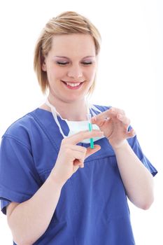 Happy smiling nurse wearing blue scrubs preparing an injection by flicking the syringe to free and expel trapped air bubbles
