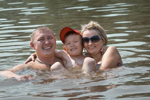 Father mother and the small son bathe in the river