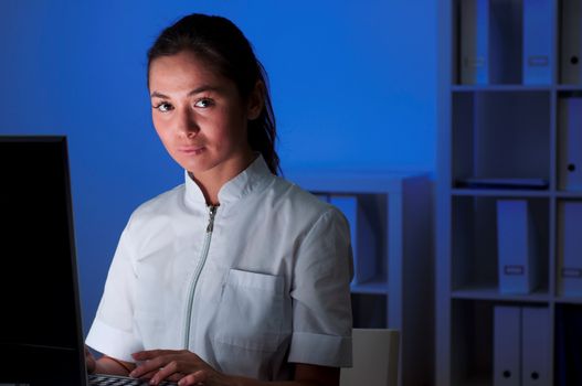 beautiful young woman doctor working at night in the office