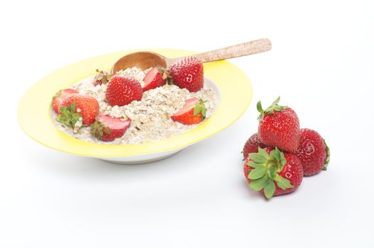 Healthy Muesli, Milk and Fresh Strawberry on Yellow plate with Wooden Spoon isolated on white background