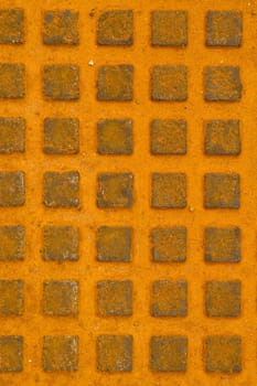 Great rusty iron metal sewer lid background. Yellow rusty steel details.