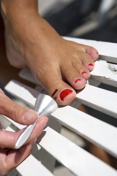 Close up of woman painting her toe nails