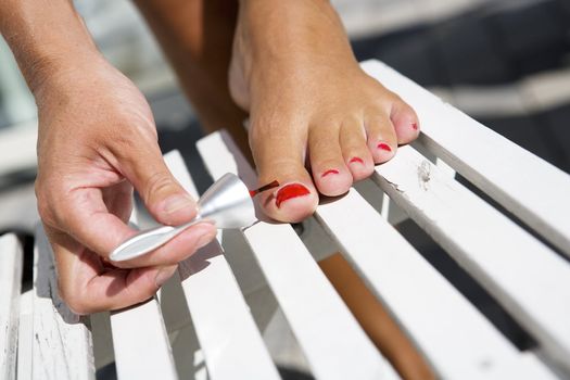 Close up of woman painting her toe nails