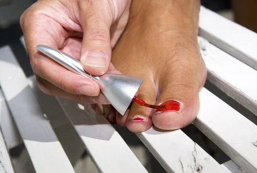 Close up of woman painting her toe nails