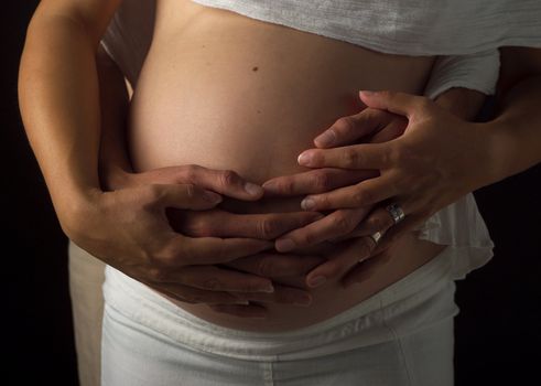 Pregnant couple holding their hands