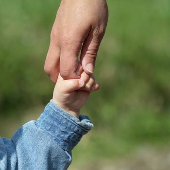 Mother and young son holding hands