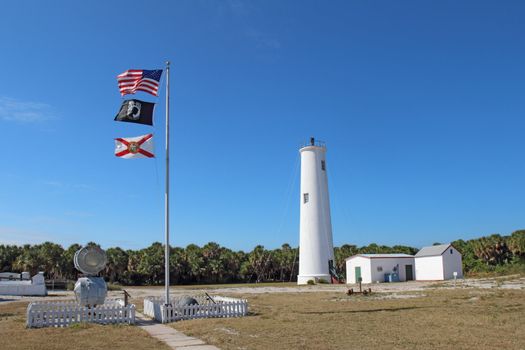 Lighthouse, flags and associated buildings at the north end of Egmont Key, a small island near the mouth of Tampa Bay, Florida