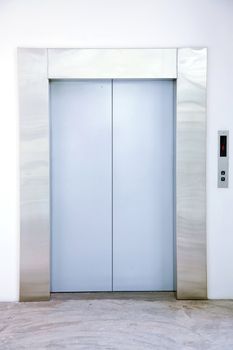 Front view of a modern elevator with closed doors in lobby