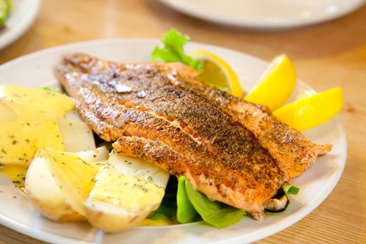 gourmet Grilled Salmon Steak with baked potato and lemon meal