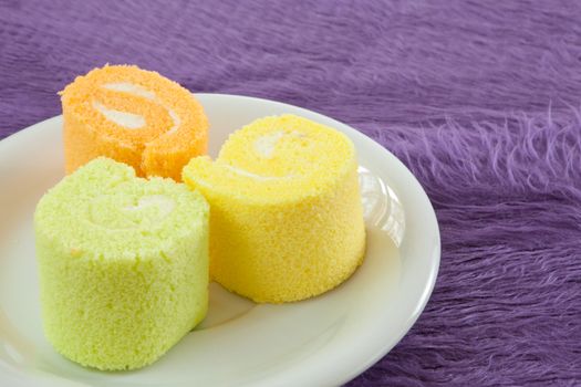 roll cake for dessert simply and freshness on purple fabric background