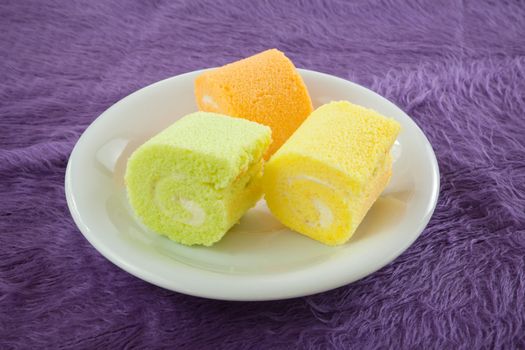 roll cake for dessert simply and freshness on purple fabric background